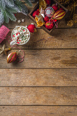 Hot chocolate with marshmallows, warm chocolate drink for Christmas morning breakfast, on wooden background with Christmas decorations, cozy winter pic copy space