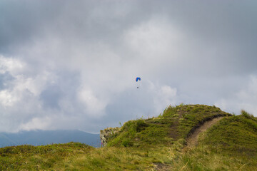 Fototapeta na wymiar Paragliding in the cloudy blue sky.