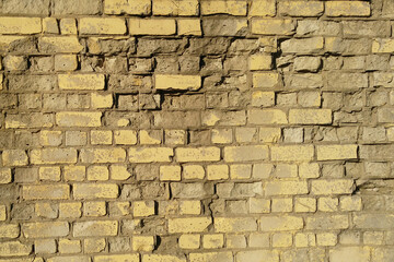 Old yellow dilapidated brick wall
