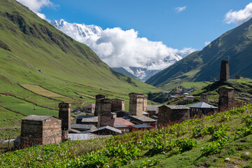 Obraz premium Ancient authentic village Ushguli, the Svaneti UNESCO World Heritage Site and one of the highest settlements in Europe. Bezengi wall and mount Shkhara, the highest mount in Georgia, on the background.