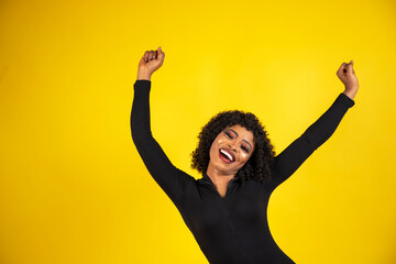 a young beautiful african lady isolated over yellow background feeling excited