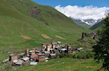 Fototapeta na wymiar Ancient authentic village Ushguli, the Svaneti UNESCO World Heritage Site and one of the highest settlements in Europe. Bezengi wall and mount Shkhara, the highest mount in Georgia, on the background.