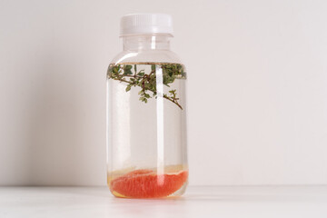 Detox Infused Water with Grapefruit and Herbs in Bottle on a White Background. Healthy Beverage. Food diet concept. Vegetarian.
