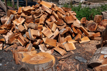 A pile of dry chopped firewood logs close up.