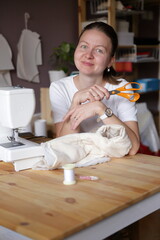 Beautiful woman cutting dress patterns in home with her little cute girl