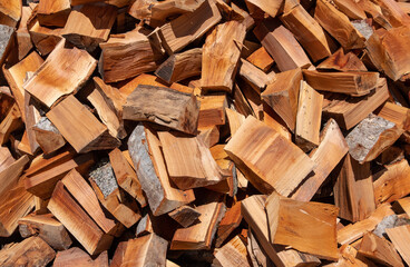 A pile of chopped firewood logs close up.
Pile of dry chopped firewood logs as a background.