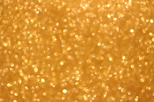 An abstract gold background with sparkle lights and bokeh. Gold blurred light.