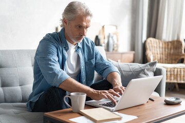 Middle-aged man working from home-office on laptop