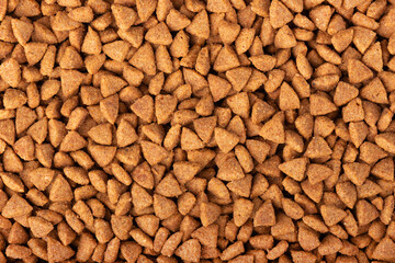 Dry pet food background. Pile of granulated animal feeds. Granules of good nutrition for dogs and...