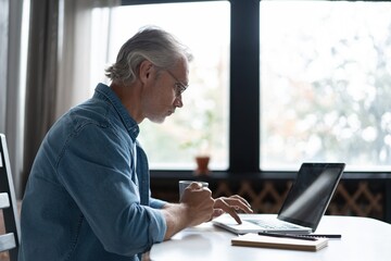 Middle-aged man working from home-office on laptop