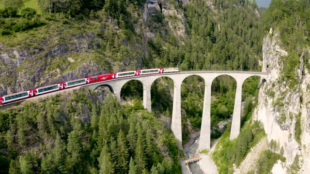 Aerial video of the Glacier Express train traversing the Landwasser viaduct. UNESCO world heritage in Switzerland