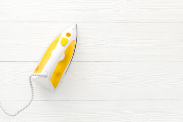 Yellow iron on ironing board. Top view, copy space
