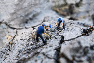 Miniature agriculture concept : Three men are using spade and various tools To help dig the groundwater or Water Well Drilling in arid areas