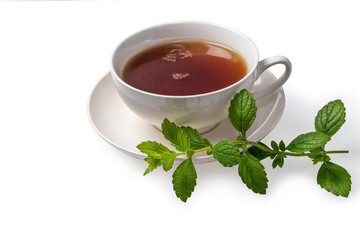 A Cup of black tea on a saucer with mint leaves on a white isolated background. Space for copying.