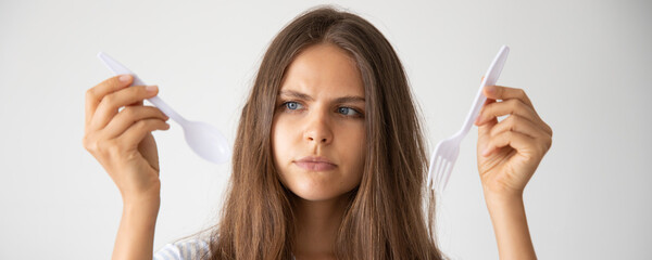 unhappy woman with single use plastic cutlery, recycle concept, banner format
