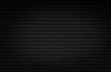 grunge black steel shutter door background and texture with vignette effect.