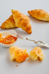 set of freshly baked croissants and orange jam