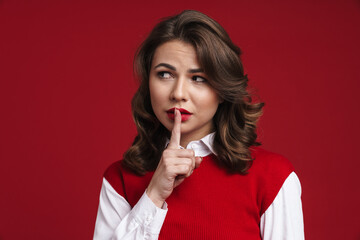 Beautiful confused girl showing silence sign at camera