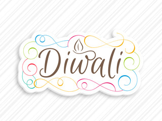 Happy Diwali greeting card with intricate calligraphy and illuminated Diwali lamp.
