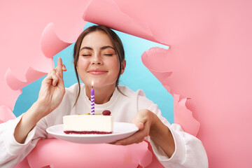 Caucasian attractive woman making wish while holding birthday cake