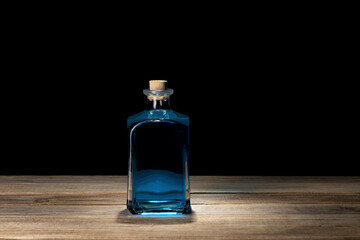 Old fashioned bottle with open cork and blue liquid. Potions and poisons concept. Conducting a...