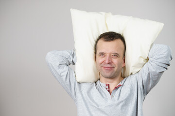 Man with pillow on grey