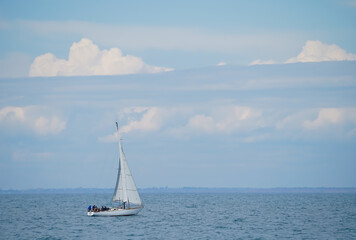 Fototapeta premium white sailboat in motion against the background of a cloudy sky