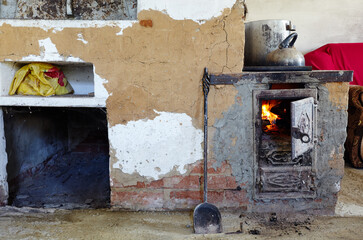 Old metal open stove door with burning flame wood. Old style cooking with large pot on open fire....