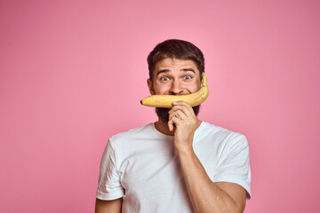 bearded man with banana in hand on pink background fun emotions model