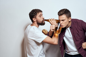 Two cheerful friends drinking beer drunk fun lifestyle communication light background