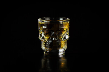 Skull-shaped glass goblet filled with cachaça