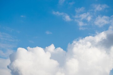 Naklejka na ściany i meble Beautiful white fluffy big clouds on a blue sky background
