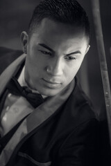 Fototapeta na wymiar Portrait of elegant young fashion latino man in formal wear tuxedo