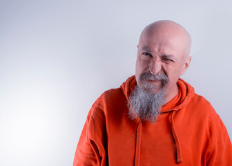 Obraz premium Middle aged man with shaved head and gray beard with displeased expression on his face