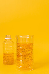 Mango drink with basil seeds with ice on a yellow background.