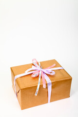 Birthday gift wrapped in simple brown paper with ribbon tied in a bow with space for copy