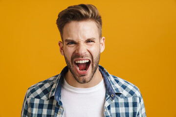 Angry handsome guy posing and screaming at camera