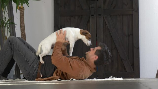 guy is playing with his dog on the floor