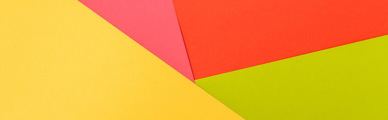 top view of colorful abstract yellow, red, green and pink paper background, panoramic shot