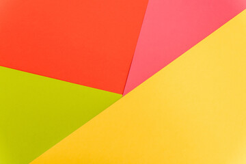 top view of colorful abstract yellow, red, green and pink paper background