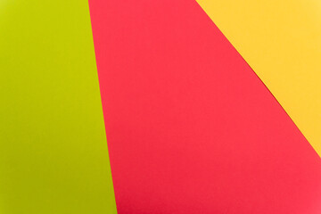 top view of colorful abstract yellow, red, green paper background