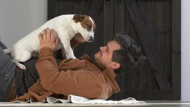 guy is playing with his dog on the floor