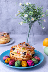 Craffin (Cruffin) with raisins, nuts and candied fruits. Easter Bread Kulich and painted eggs. Easter Holiday. Close-up.