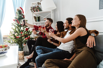 Image of friends taking selfie on mobile phone while drinking wine