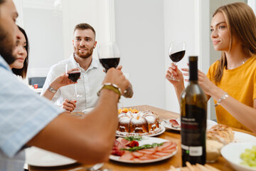 Image of friends eating pie and drinking wine while having lunch