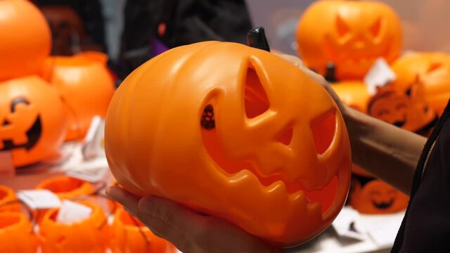Close up of plastic version of carved Halloween pumpkin. Holiday season shopping concept. 