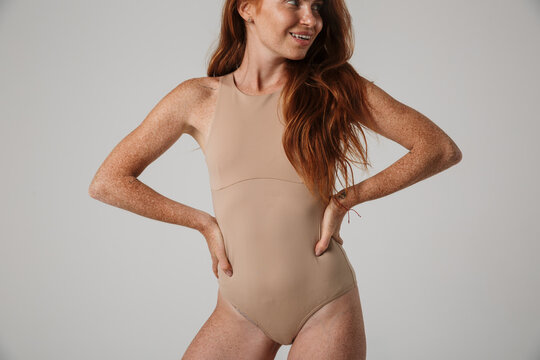 Beautiful young woman with long red hair in bodysuit