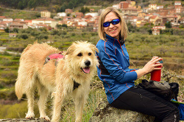 BLOND WOMAN HIKING WITH DOG