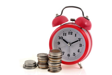 Piles de pièces de monnaie et réveil sur fond blanc