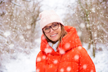 Woman enjoys snowfall in the forest